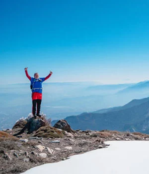 man celebrating on top of mountain