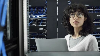 Female Engineer Works with Laptop in Data Center