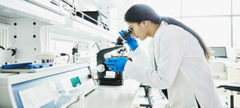 scientist looking in microscope