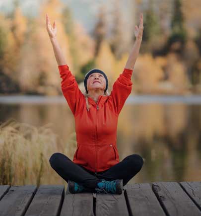 woman sitting on dock doing yoga