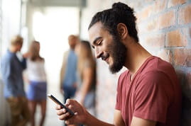 Man looking on mobile with a smile