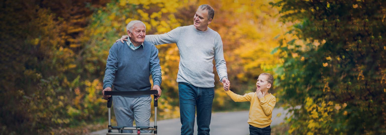 one mid aged person with an old man and kid, walking