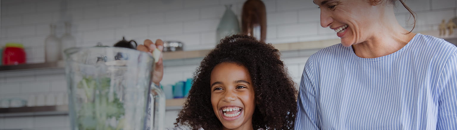 girl with her mother using mixer grinder