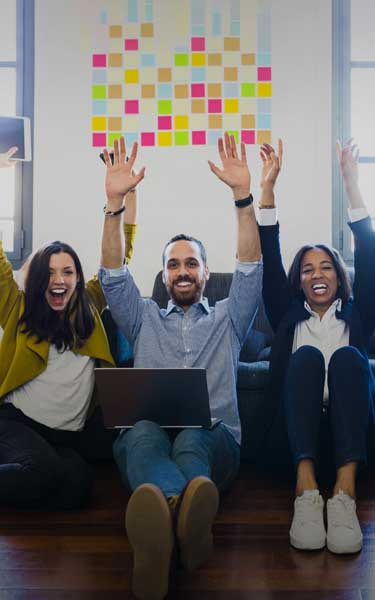 happy colleagues cheering sitting on floor