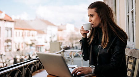 woman sipping coffee on balcony