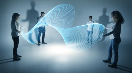 Four people on a white background with shadows playing with digital waves