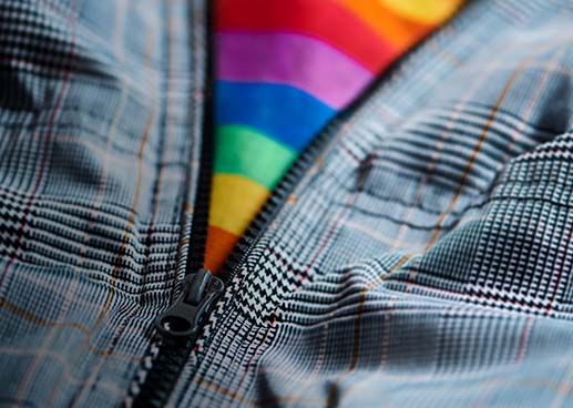 Zipper unzipping revealing a rainbow patterened shirt