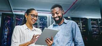 two colleagues in server room looking at tablet