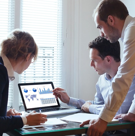 colleagues looking over stats on screen