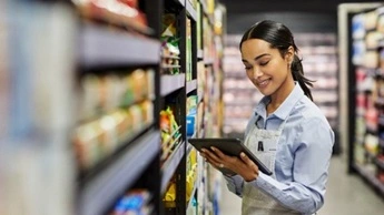 Shot of a young woman using a tablet at work in a supermarket