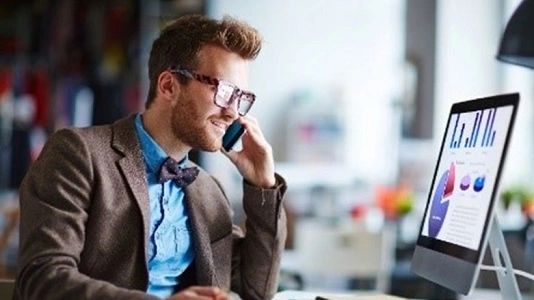 man on mobile looking at desktop screen