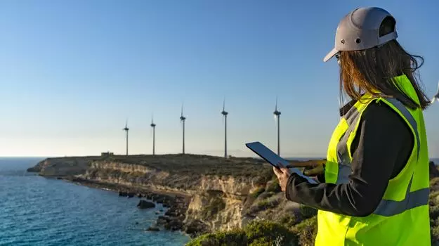 employee overlooking wind turbines