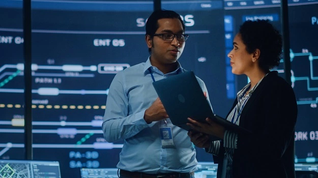 male and female colleagues speaking over laptop 