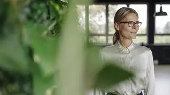 woman surrounded by plants looking off to the side