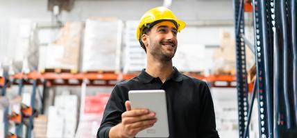 man wearing hard hat smiling in warehouse