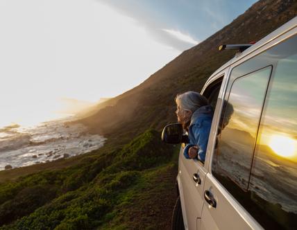 person with head out of car window admiring the view