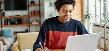 Teenager studying on laptop at the desk