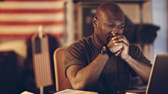 man from US army looking at laptop