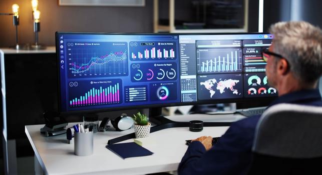 Employee looking at graphs and charts on his screen