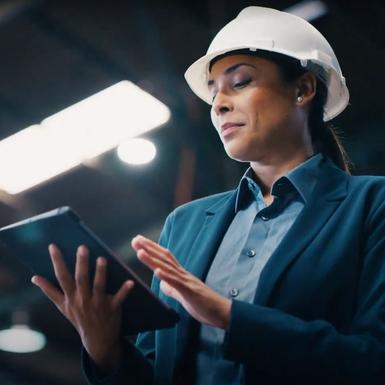 woman in hard hat looking at tablet