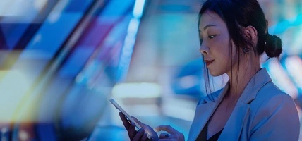 woman looking at mobile in lit hallway