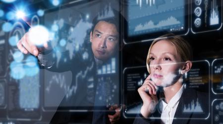 Man and woman pointing at floating computer screens with star systems