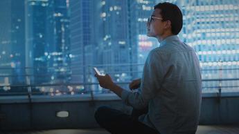 Young businessman looking at smartphone on the roof