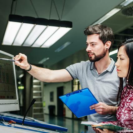 man showing lady data analysis on computer screen