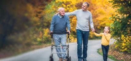 three generations walking on path in fall