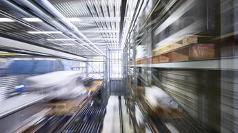 Narrow alley amidst blurred motion of racks